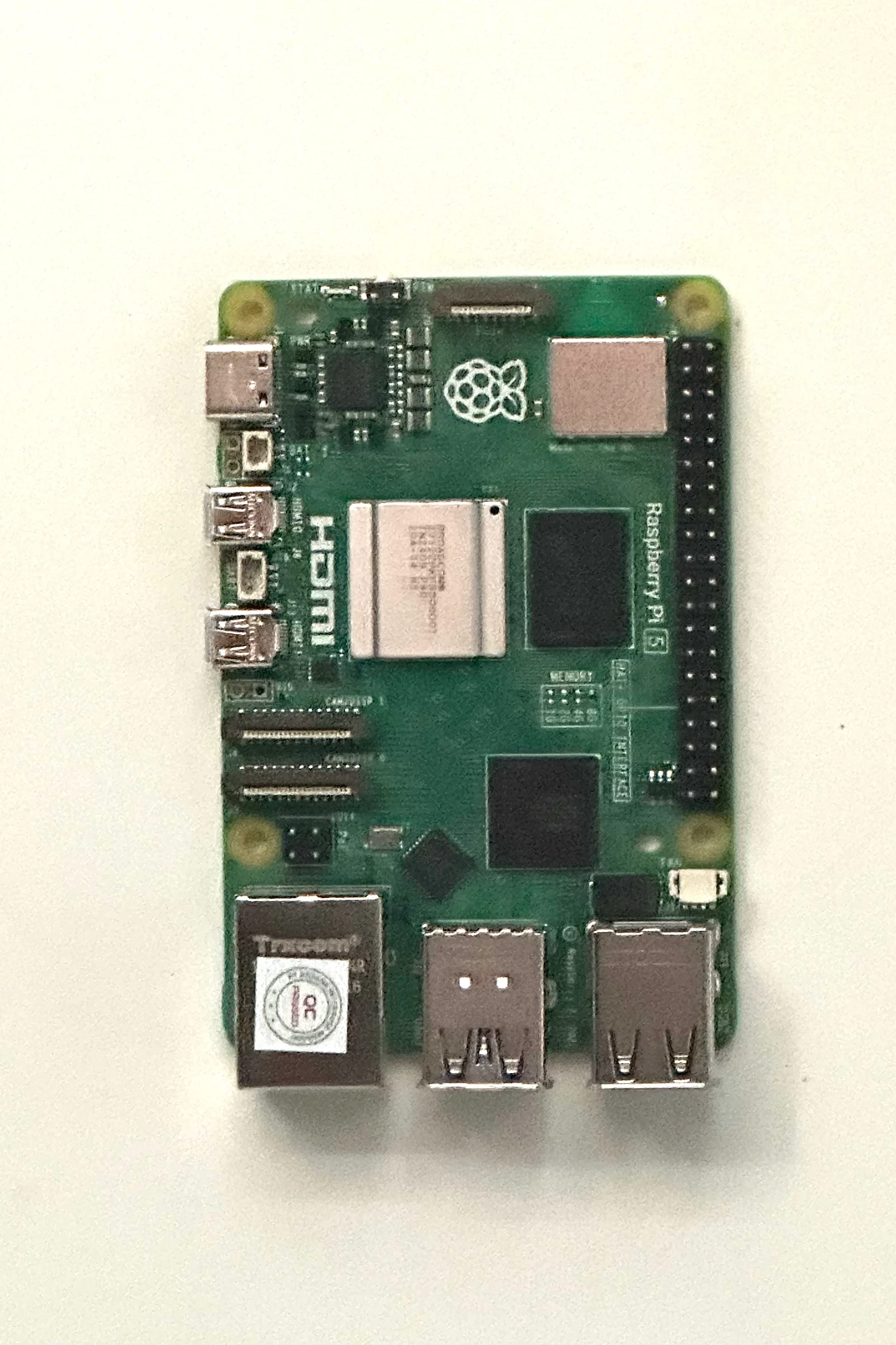 A bare Raspberry Pi 5 on a white table
